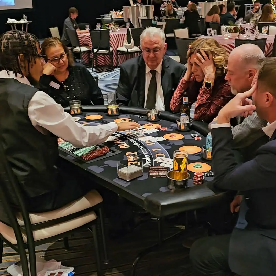 Guests gathered around a blackjack table with a professional dealer